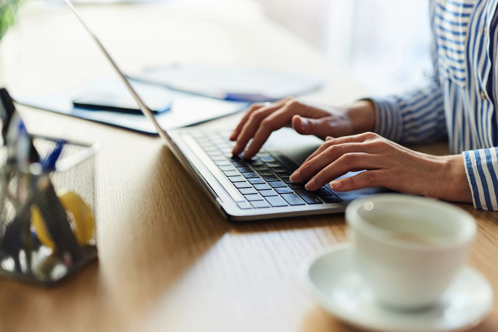 Person typing on a laptop while writing a product review